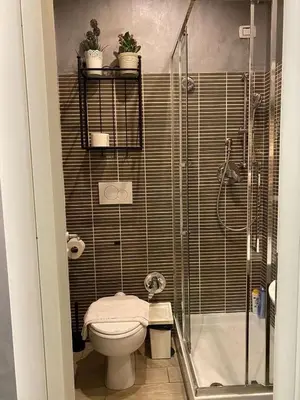 a small bathroom with a toilet and a shower at Rome Orange Inn in Rome
