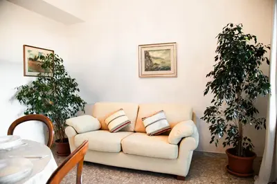 a living room with a couch and two plants at AURELIA LORIS HOUSE in Rome
