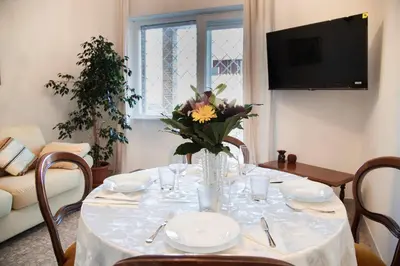 a dining room table with a vase of flowers on it at AURELIA LORIS HOUSE in Rome