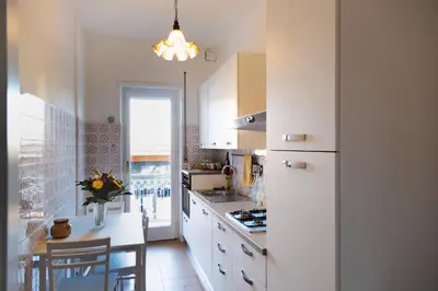 a kitchen with white cabinets and a white refrigerator at AURELIA LORIS HOUSE in Rome