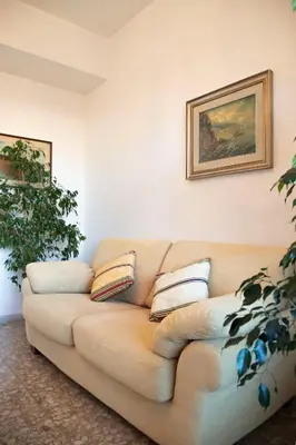 a living room with aige couch with pillows on it at AURELIA LORIS HOUSE in Rome