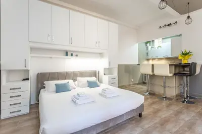 a white bedroom with a bed and a sink at Central Charm near Piazza Navona - Cozy Loft for 2 in Rome