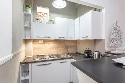 a kitchen with white cabinets and a sink at Central Charm near Piazza Navona - Cozy Loft for 2 in Rome