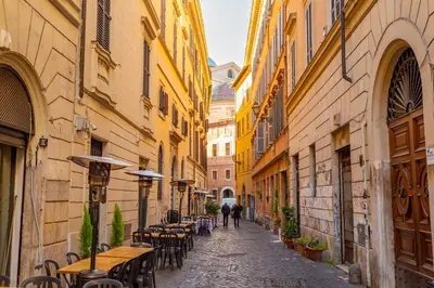 an alley with tables and chairs in an old town at Central Charm near Piazza Navona - Cozy Loft for 2 in Rome