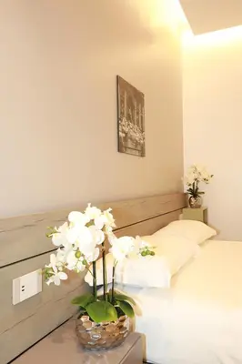 a bedroom with a bed and a vase with white flowers at Unique Luxury Stay in Rome