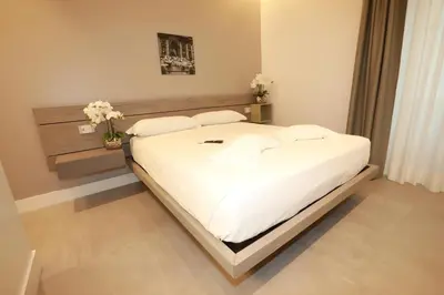 a bedroom with a large bed with white sheets and pillows at Unique Luxury Stay in Rome