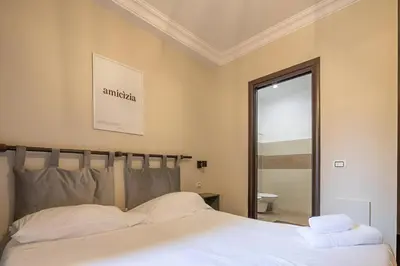 a bedroom with a white bed and a mirror at Ghetto BuddyRent in Rome