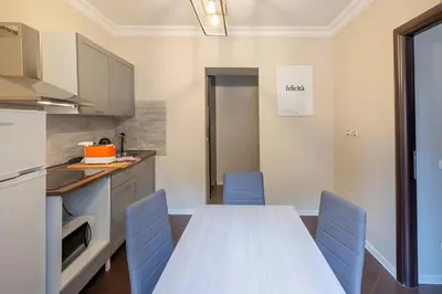 a kitchen with a white table and blue chairs at Ghetto BuddyRent in Rome