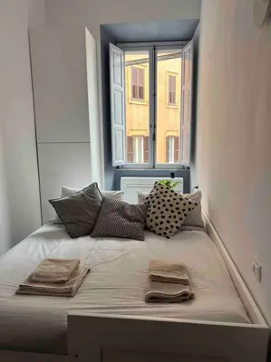 a bed with towels and a window in a room at Lovely art&design 2 bdrms flat in Rome