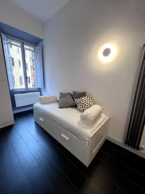 a small bed in a room with a window at Lovely art&design 2 bdrms flat in Rome