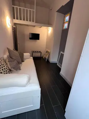 a living room with a white couch and a tv at Lovely art&design 2 bdrms flat in Rome