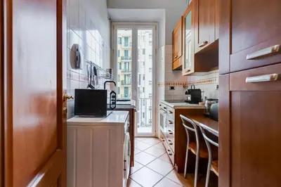 a kitchen with wooden cabinets and a window at Historia et Elegantia - vicino il Colosseo, Circo Massimo e Trastevere in Rome