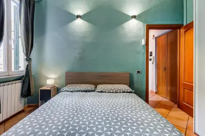 a bedroom with a large bed with a blue wall at Historia et Elegantia - vicino il Colosseo, Circo Massimo e Trastevere in Rome