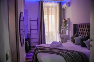 a purple bedroom with a bed and a window at Matriosca Suites in Rome