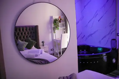 a bathroom with a mirror and a tub and a bed at Matriosca Suites in Rome