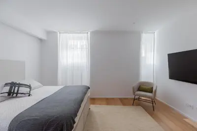 a bedroom with a bed and a tv and a chair at Saint Peter Caesar Suites in Rome
