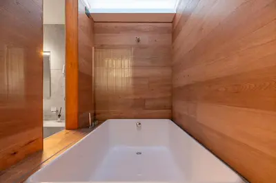a large white bath tub in a bathroom with wooden walls at Saint Peter Caesar Suites in Rome
