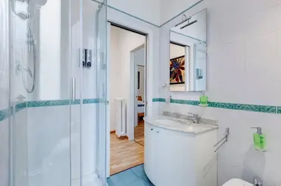 a white bathroom with a sink and a shower at Clemente XII Al Quirinale House in Rome