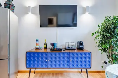 a blue table in a kitchen with a tv at Clemente XII Al Quirinale House in Rome