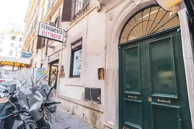 a group of motorcycles parked next to a building with a green door at Trevi's BuddyRent in Rome