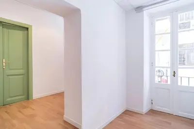 an empty room with a green door and white walls at Trevi's BuddyRent in Rome