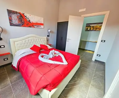 a bedroom with a red bed with towels on it at Domitia Vatican Luxury Apartment in Rome