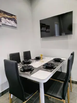 a white table with black chairs and a television at Domitia Vatican Luxury Apartment in Rome