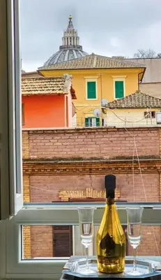 a bottle of wine sitting on a table with two glasses at Domitia Vatican Luxury Apartment in Rome