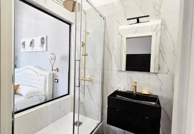 a bathroom with a shower and a sink and a mirror at Domitia Vatican Luxury Apartment in Rome