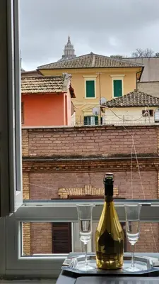a bottle of wine sitting on a table with two glasses at Domitia Vatican Luxury Apartment in Rome