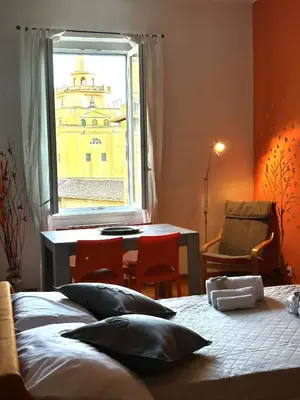 a bedroom with a bed and a table and a window at Appartamento Residenza Girasole Vatican in Rome