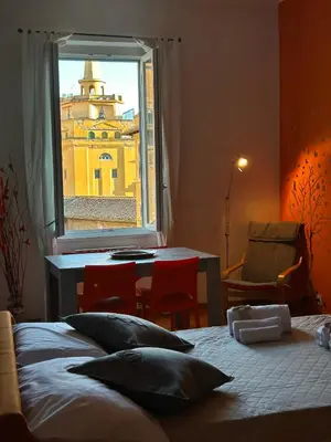 a bedroom with a bed and a window with a table at Appartamento Residenza Girasole Vatican in Rome