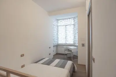 a small bedroom with a bed and a desk at Gabbo - House in Rome
