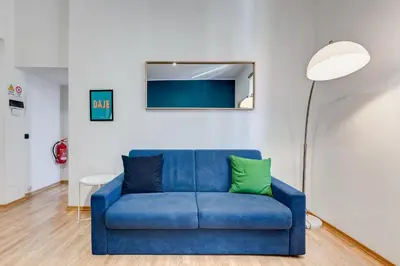 a blue couch in a living room with a lamp at Salotto San Pietro in Rome