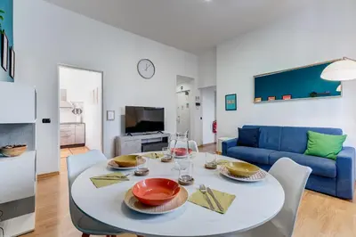 a living room with a white table and a blue couch at Salotto San Pietro in Rome