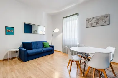 a living room with a blue couch and a table at Salotto San Pietro in Rome