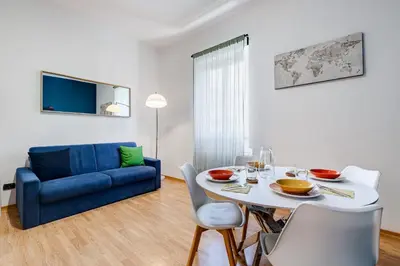 a living room with a table and a blue couch at Salotto San Pietro in Rome