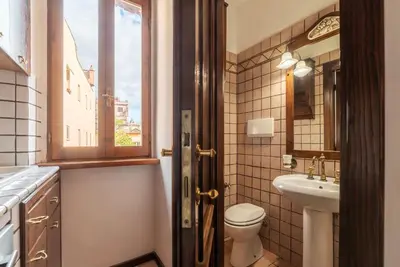 a bathroom with a toilet and a sink and a window at GuestHost - Trastevere Leopard'Oro Apartment in Rome