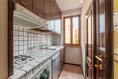 a kitchen with a stove top oven next to a window at GuestHost - Trastevere Leopard'Oro Apartment in Rome
