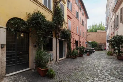 an alley with potted plants on the side of buildings at GuestHost - Trastevere Leopard'Oro Apartment in Rome