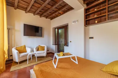a bedroom with a bed and a couch and a tv at GuestHost - Trastevere Leopard'Oro Apartment in Rome