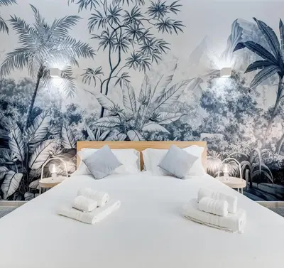 a bedroom with a large bed with a tropical wallpaper at CasaVibe Vaticano in Rome
