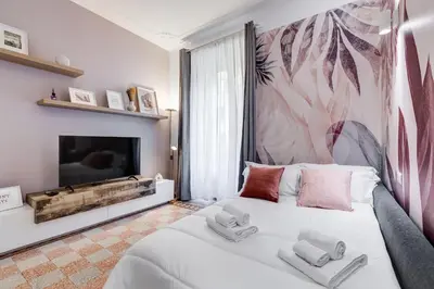 a bedroom with a white bed and a tv at CasaVibe Vaticano in Rome