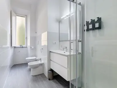 a white bathroom with a toilet and a sink at CasaVibe Vaticano in Rome
