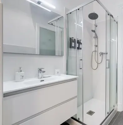 a white bathroom with a shower and a sink at CasaVibe Vaticano in Rome