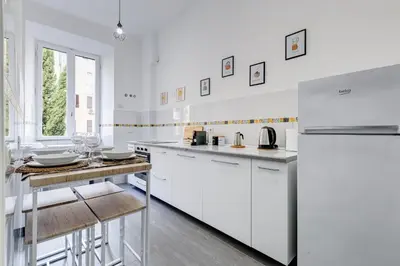 a white kitchen with white cabinets and a counter at CasaVibe Vaticano in Rome
