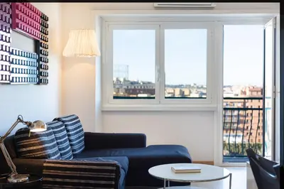 a living room with a blue couch and two windows at Piramide view by Rental in Rome in Rome