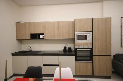 a kitchen with wooden cabinets and a microwave at Irene's Home The Retreat in Rome