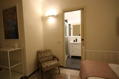 a bedroom with a bed and a chair and a mirror at Irene's Home The Retreat in Rome