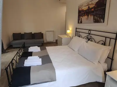 a bedroom with a large white bed with a couch at White King Rooms in Rome